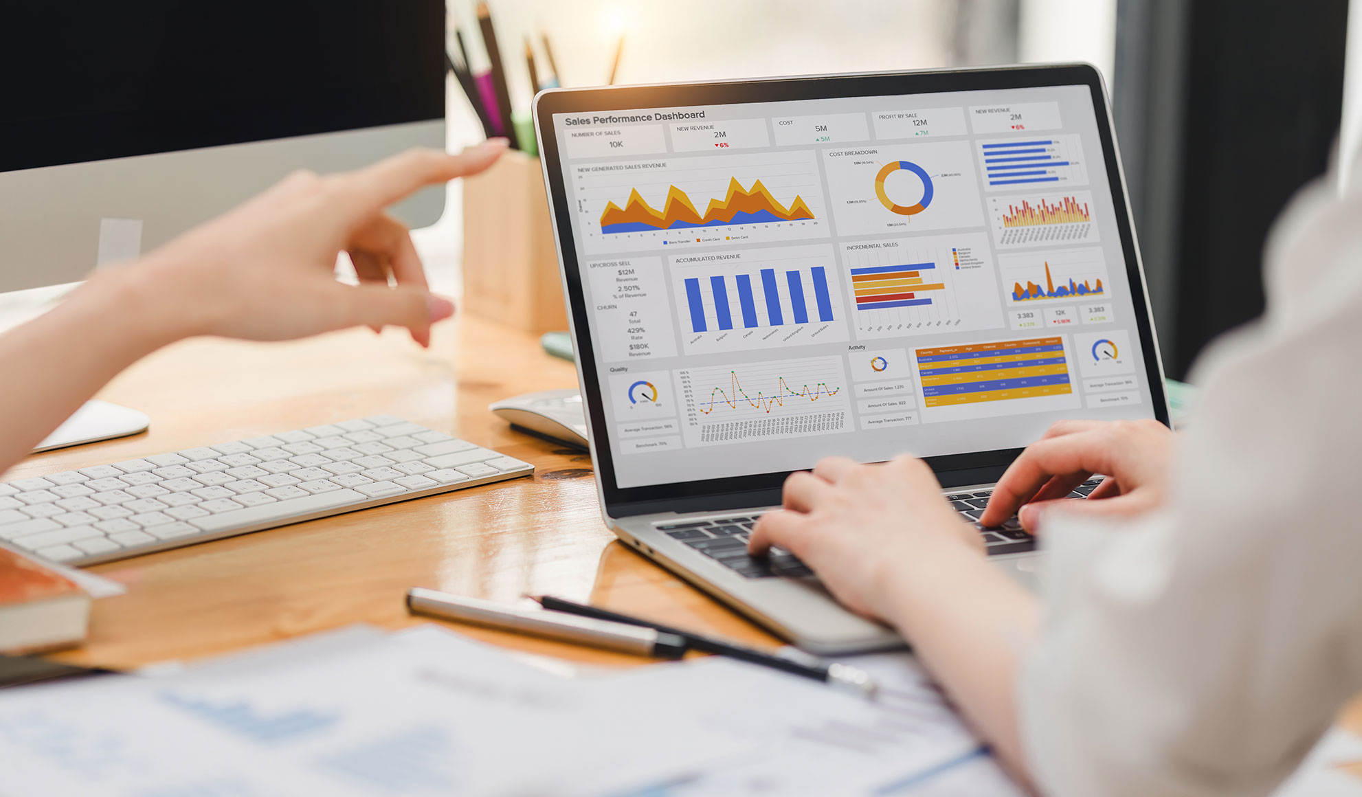KPIs Two businesspeople or an accountant team are analyzing data charts, graphs, and a dashboard on a laptop screen in order to prepare a statistical report and discuss financial data in an office